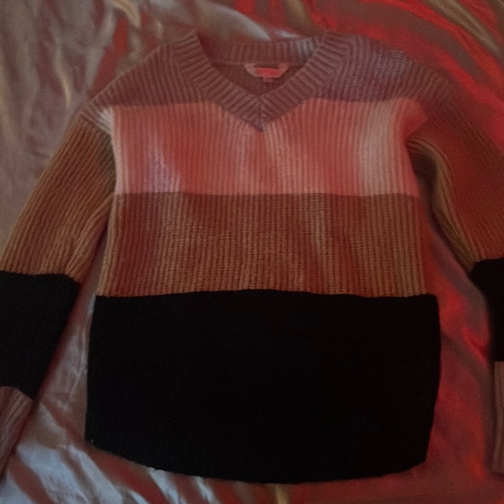 a black , beige ,white and grey sweater .